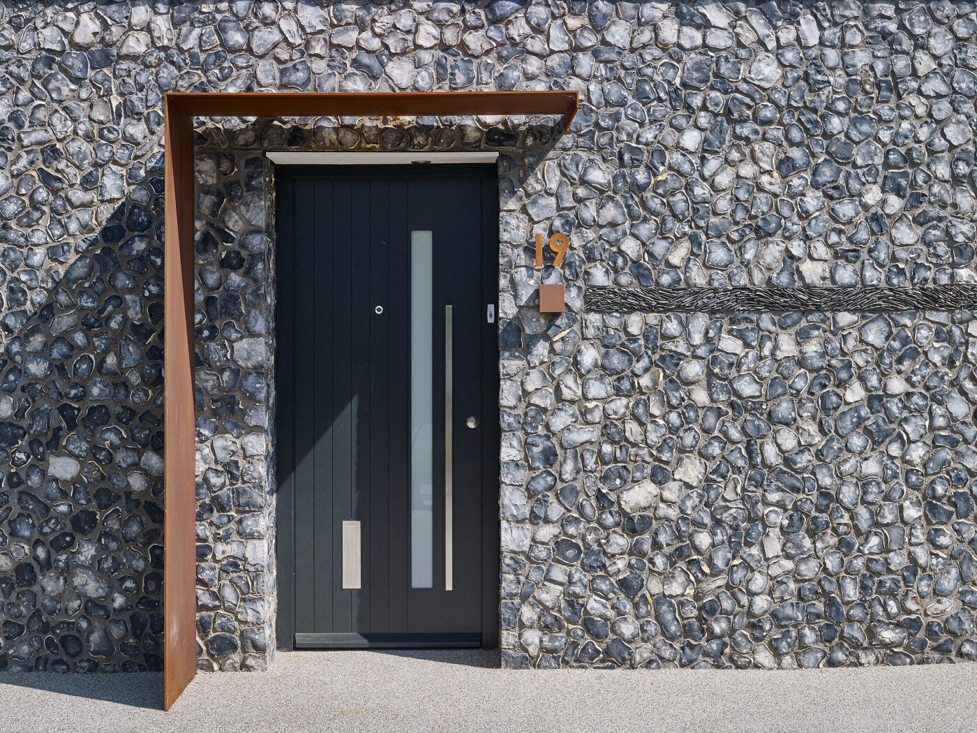A rust overhang/porch and rust number mixed with stainless steel accessories