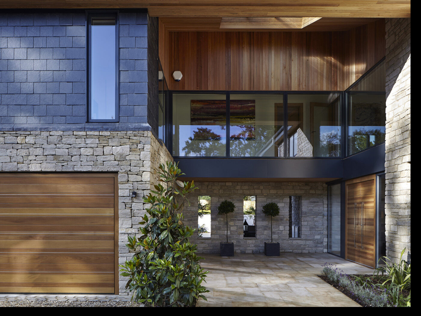 This uniquely designed house has a glass walkway/balcony on the first floor, creating a fantastic focal point just above the double entrance door underneath