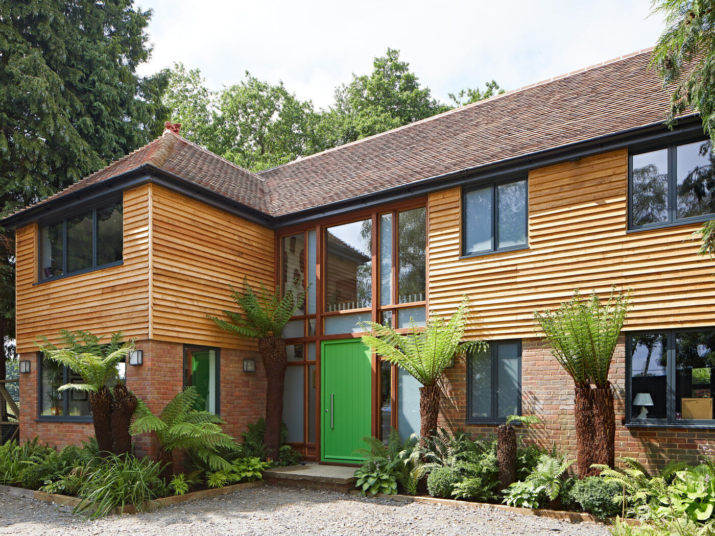 While the vibrant green door is clearly an eye-catcher, the natural oak cladding across the first floor frontage ensures the whole facade creates impact