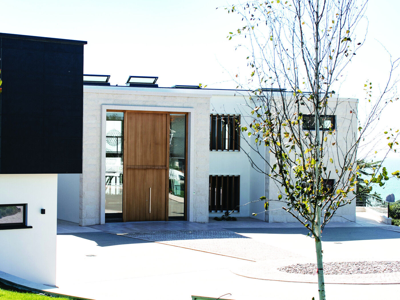 Size is everything - this frontage features the illusion of a double height door with an overhead wood panel & matching double height glazing for maximum impact