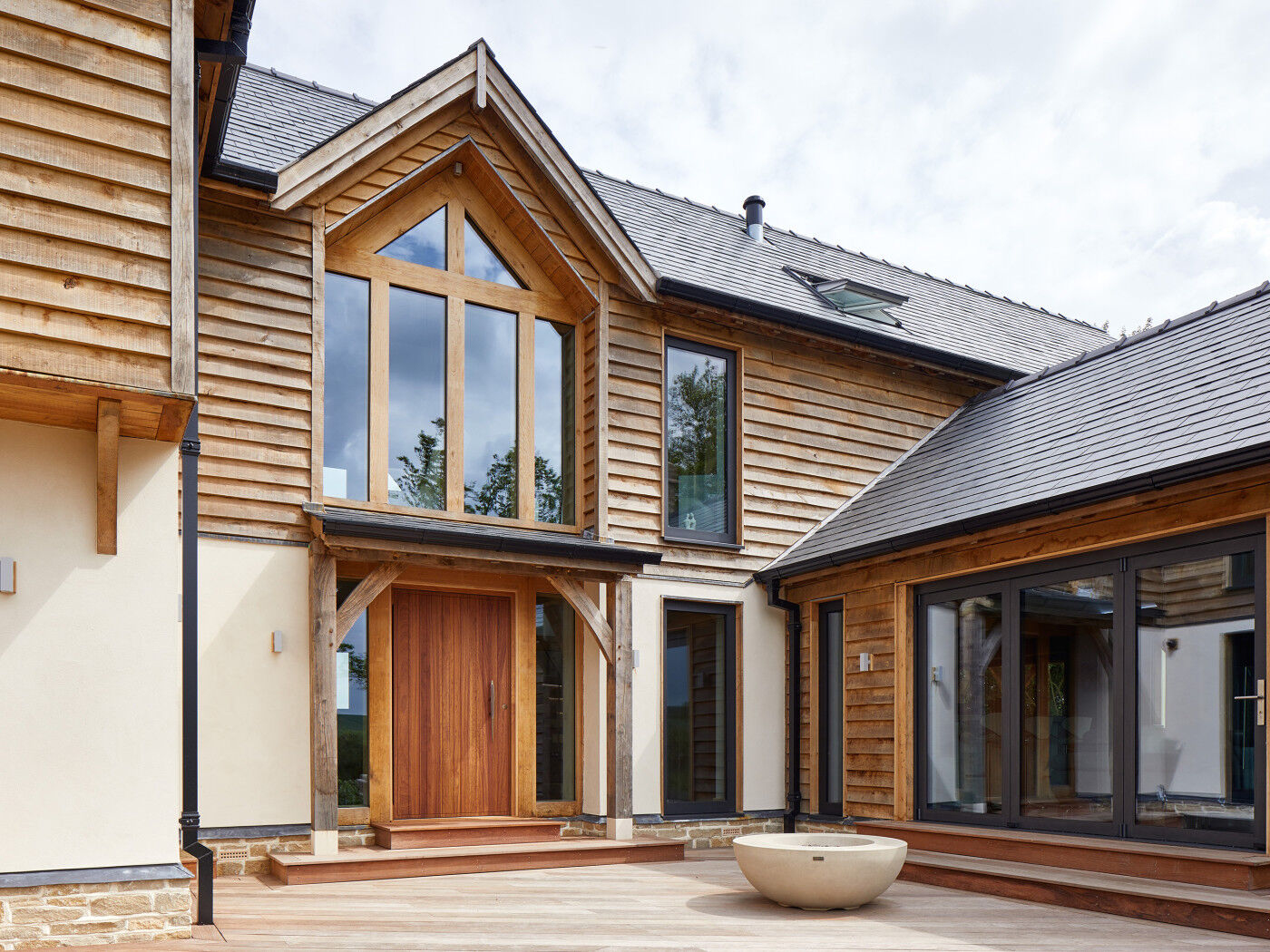 This modern build benefits from wide steps, a big door with glass framing & an artfully placed oversized planter