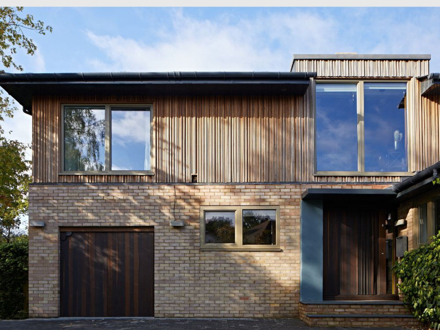 The iroko cladding works beautifully with the fumed oak front and garage doors.