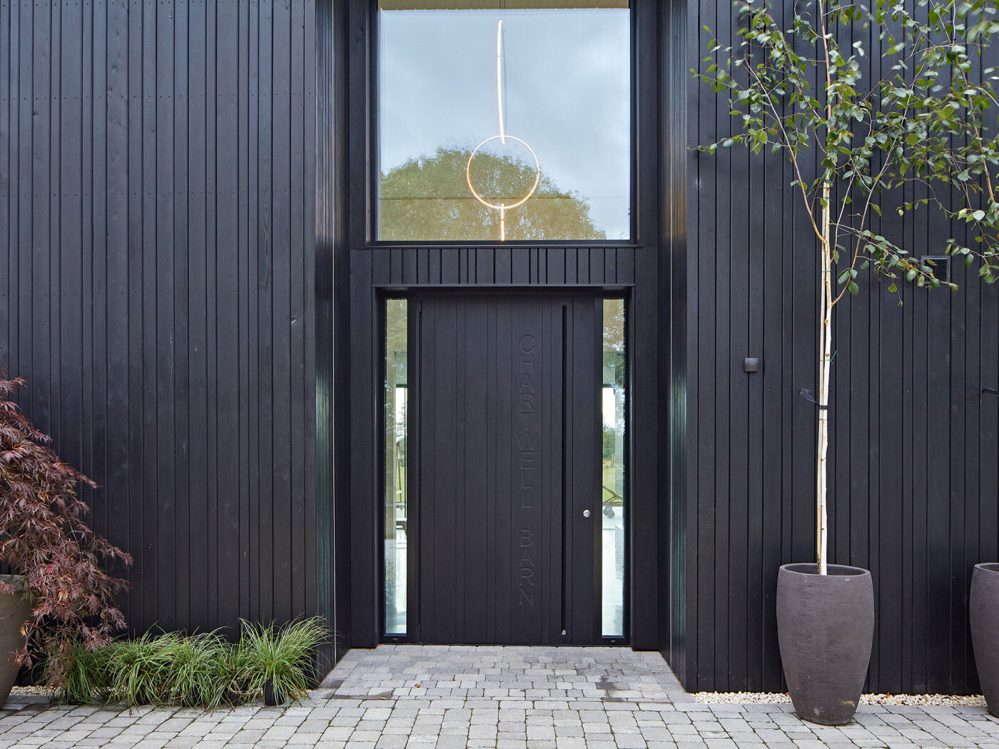 Sleek and modern, the "Chartwell Barn" project used an ebony-oiled oak wood door to match to the exterior cladding