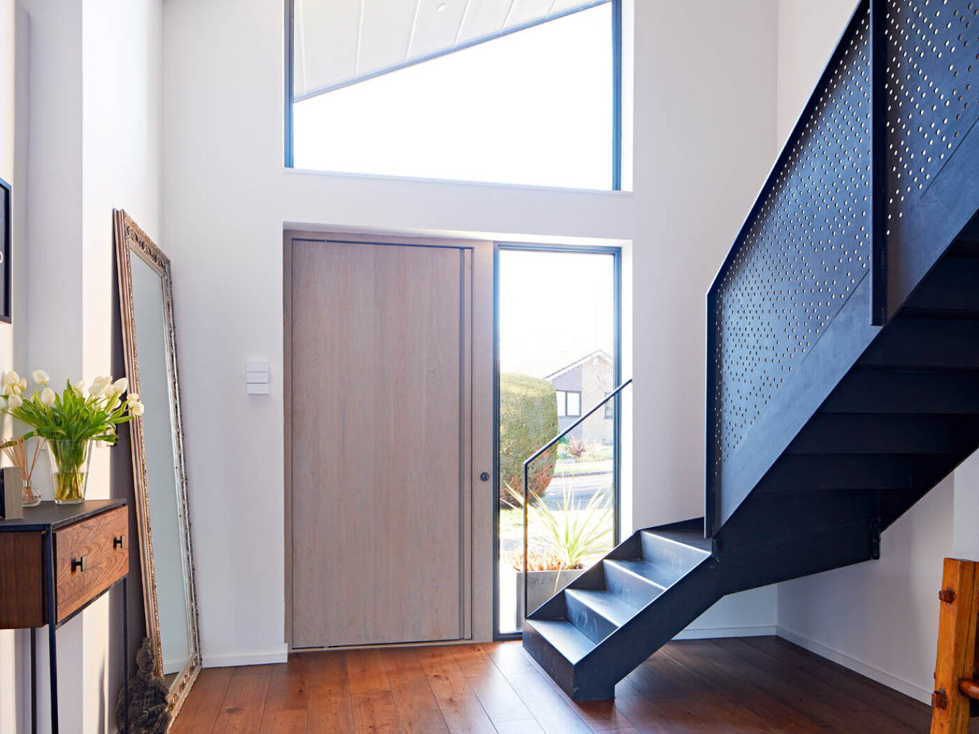 The simplicity of the "Raw" design is accentuated by a grey oil finish and concealed handle, allowing the dramatic staircase to become the focal point of the interior