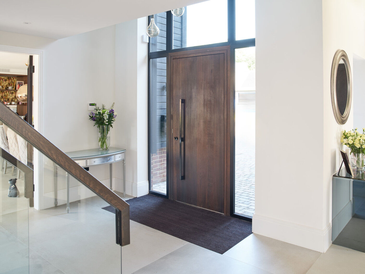 White walls and flooring contrast with the beautiful dark fumed oak door 