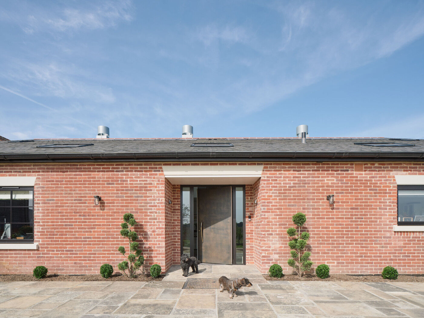 The bronze door with sidelights looks great against the brick finish.