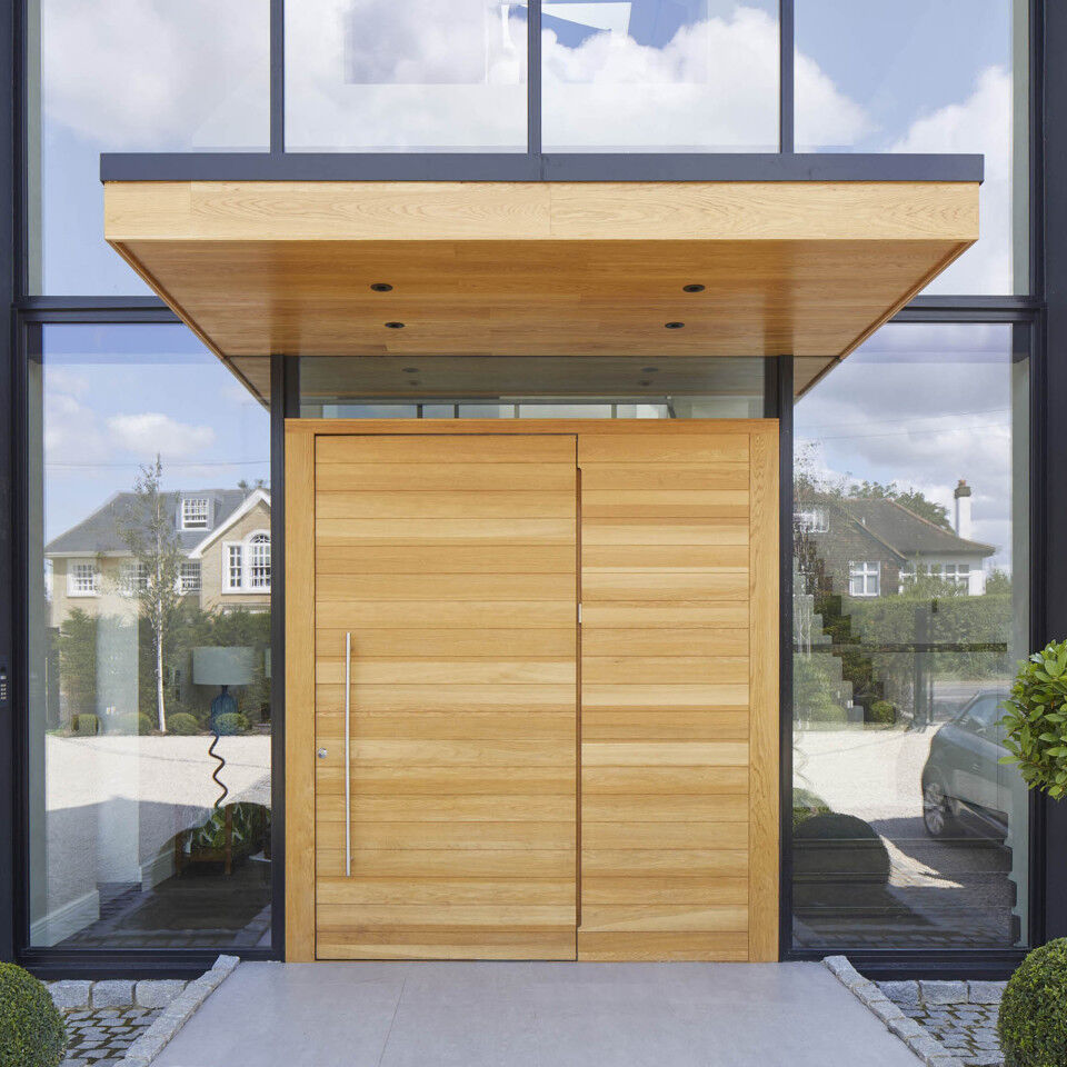 This metal & wooden front door canopy extends a long way in front of this pivot door to give shelter from sun & rain