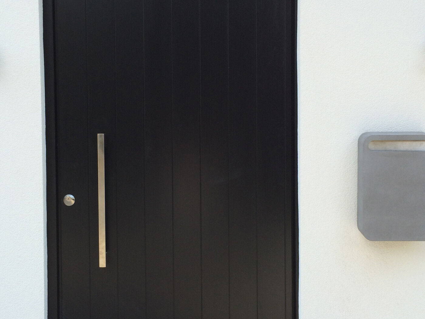 contemporary concrete postbox on the wall near the door