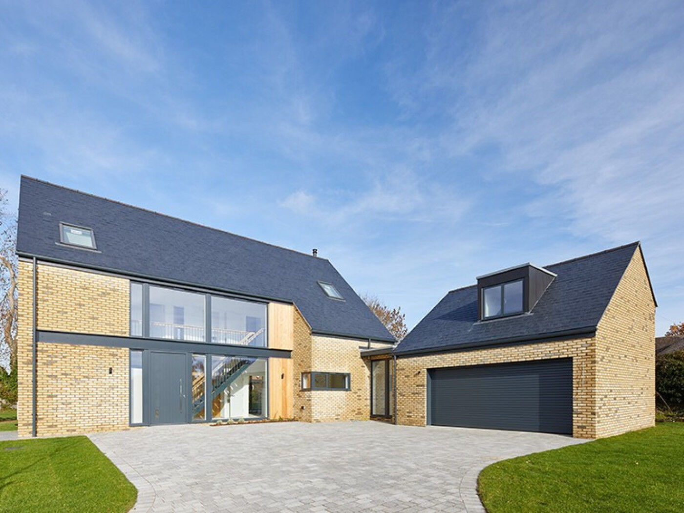Set into architectural glass, the dark grey front door matches perfectly with the external building materials