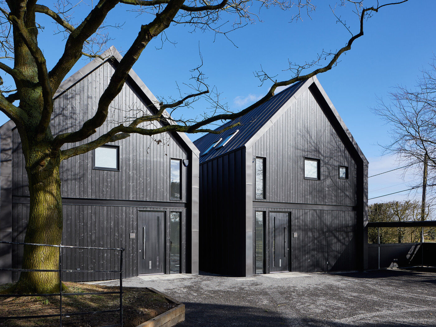 These contemporary houses were designed to mimic farm buildings, complete with black cladding & black exterior doors