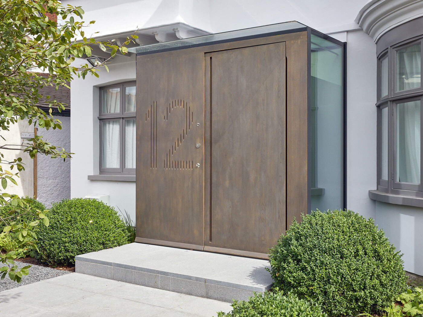 Raw E80 pivot door set with matching boarded panel with number engraving in European stained Onyx metallic finish 