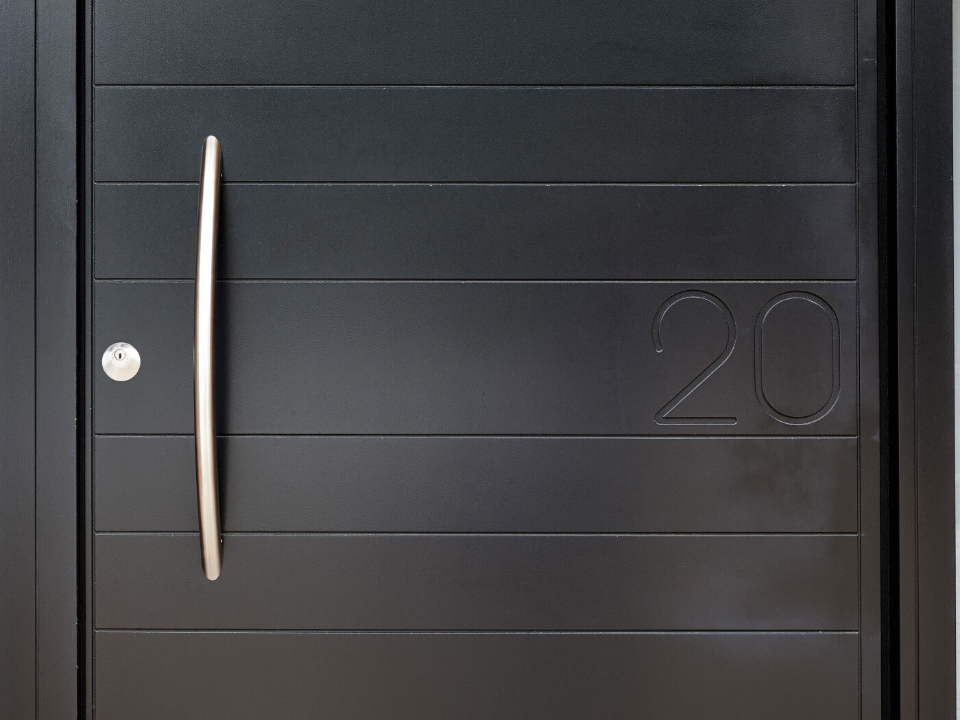 The house number is clearly visible but doesn't overpower the contemporary door