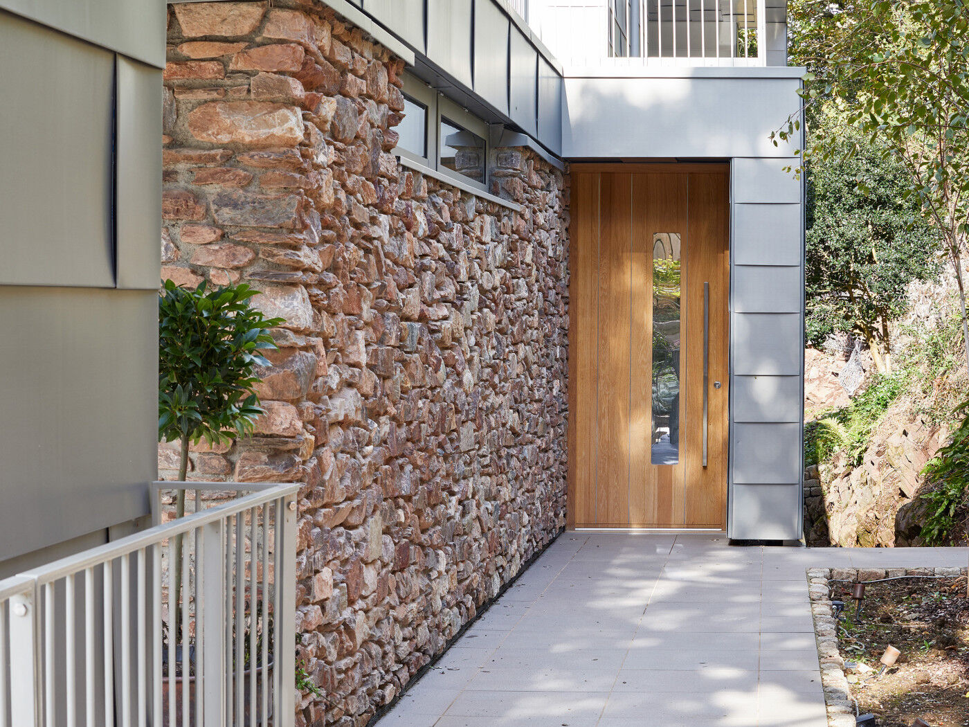 The Urban Front europan oak front door is framed by stone & zinc