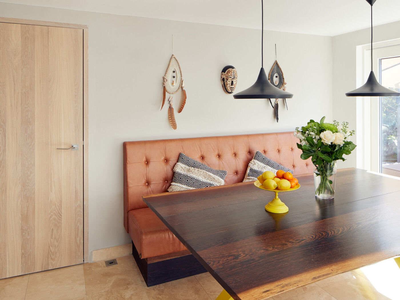 The dining area maintains the flow of more natural tones, punctuated by key splashes of colour like the fruit bowl & yellow legs on the table
