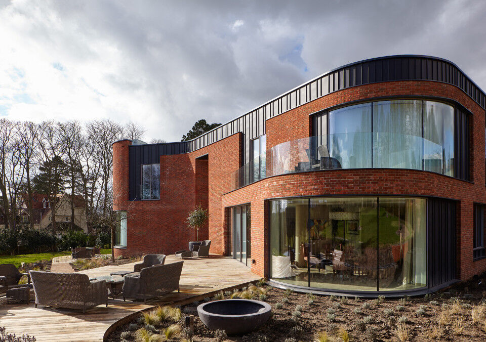 The curved passive house design features 5 Urban Front external doors 