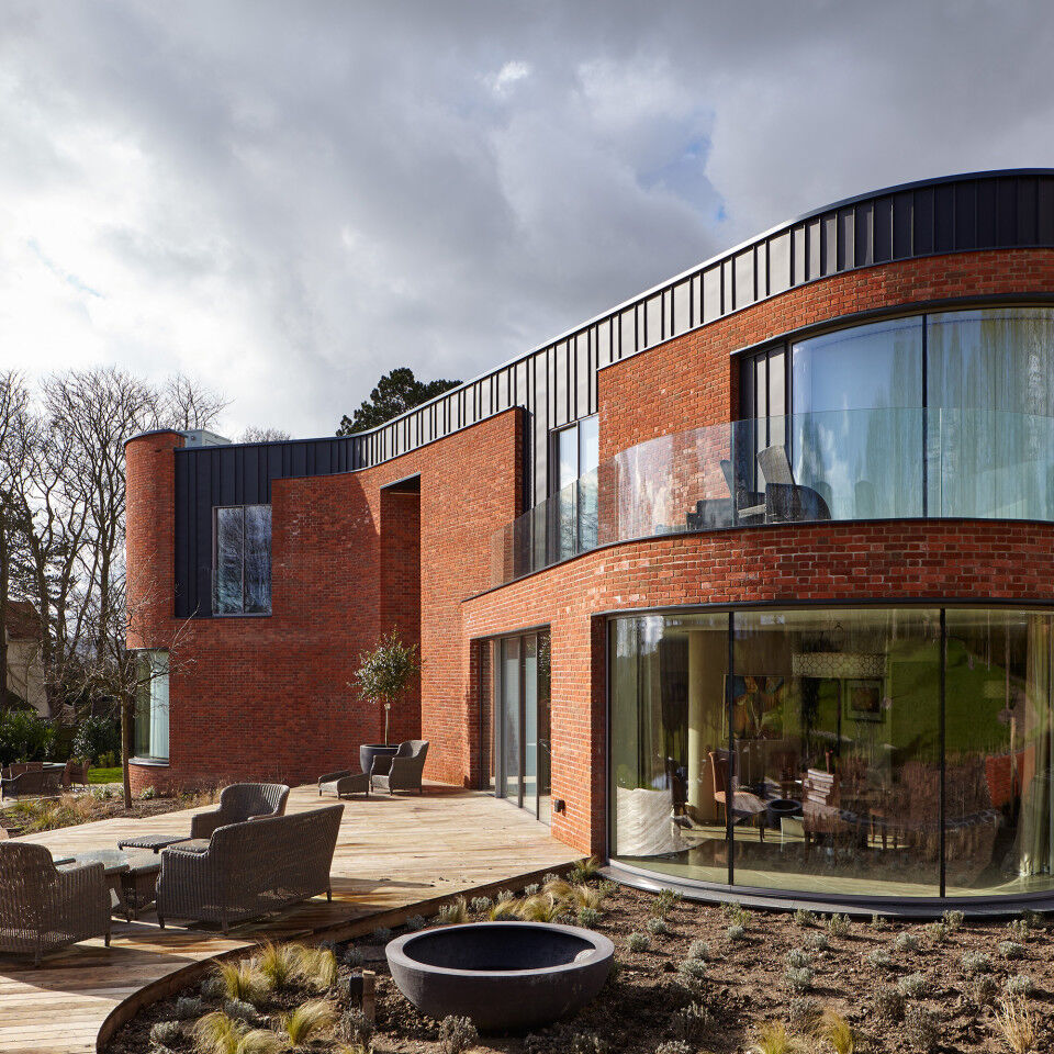 The curved passive house design features 5 Urban Front external doors 