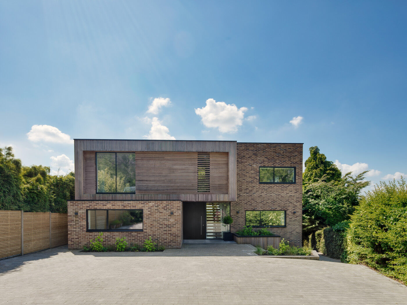 A  contemporary renovation project features a black door that matches the window frames and chimes with the bricks.