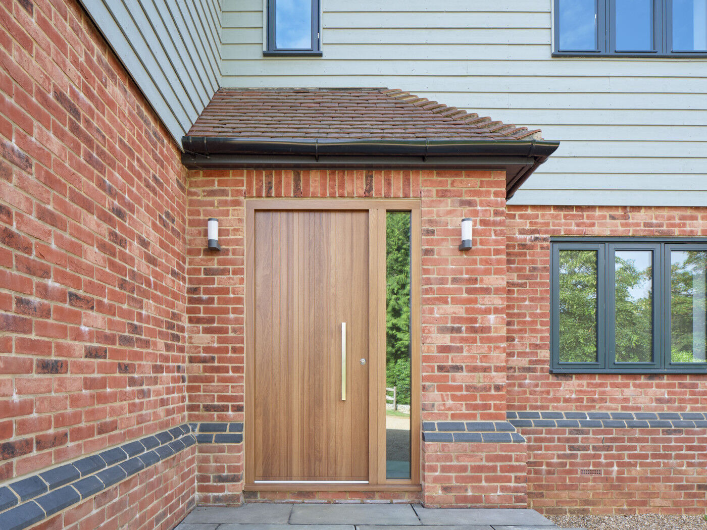 The oak door provides a point of difference for this traditional style home with the window frame colour echoed in the brickwork.