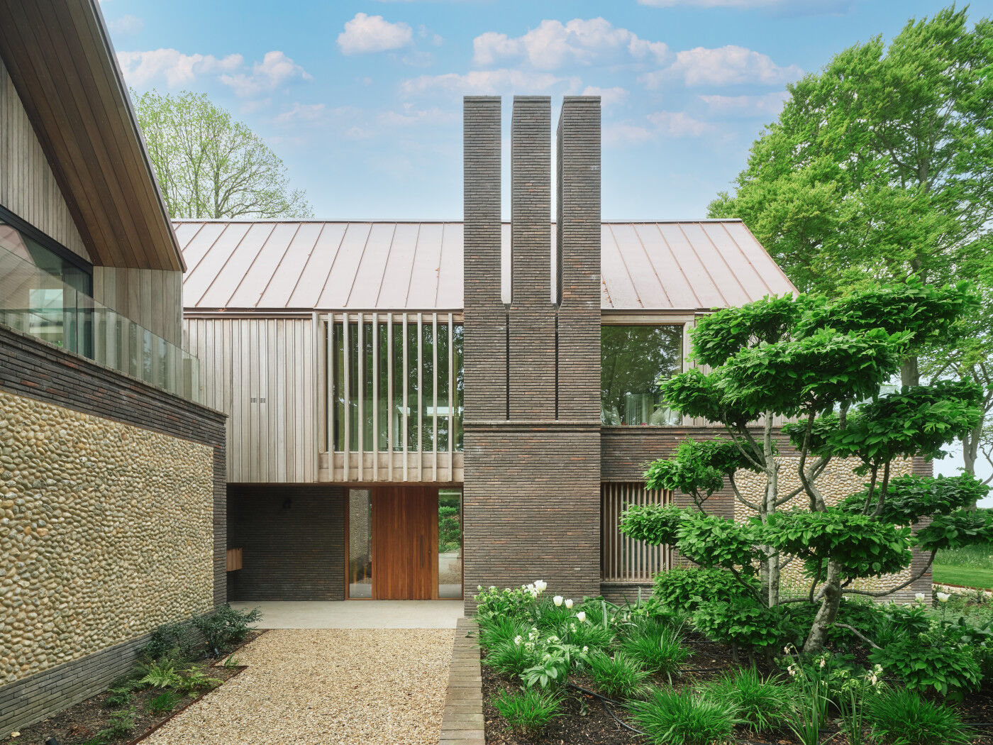Textures and shapes a plenty in this contemporary home with an inviting door in versatile iroko.