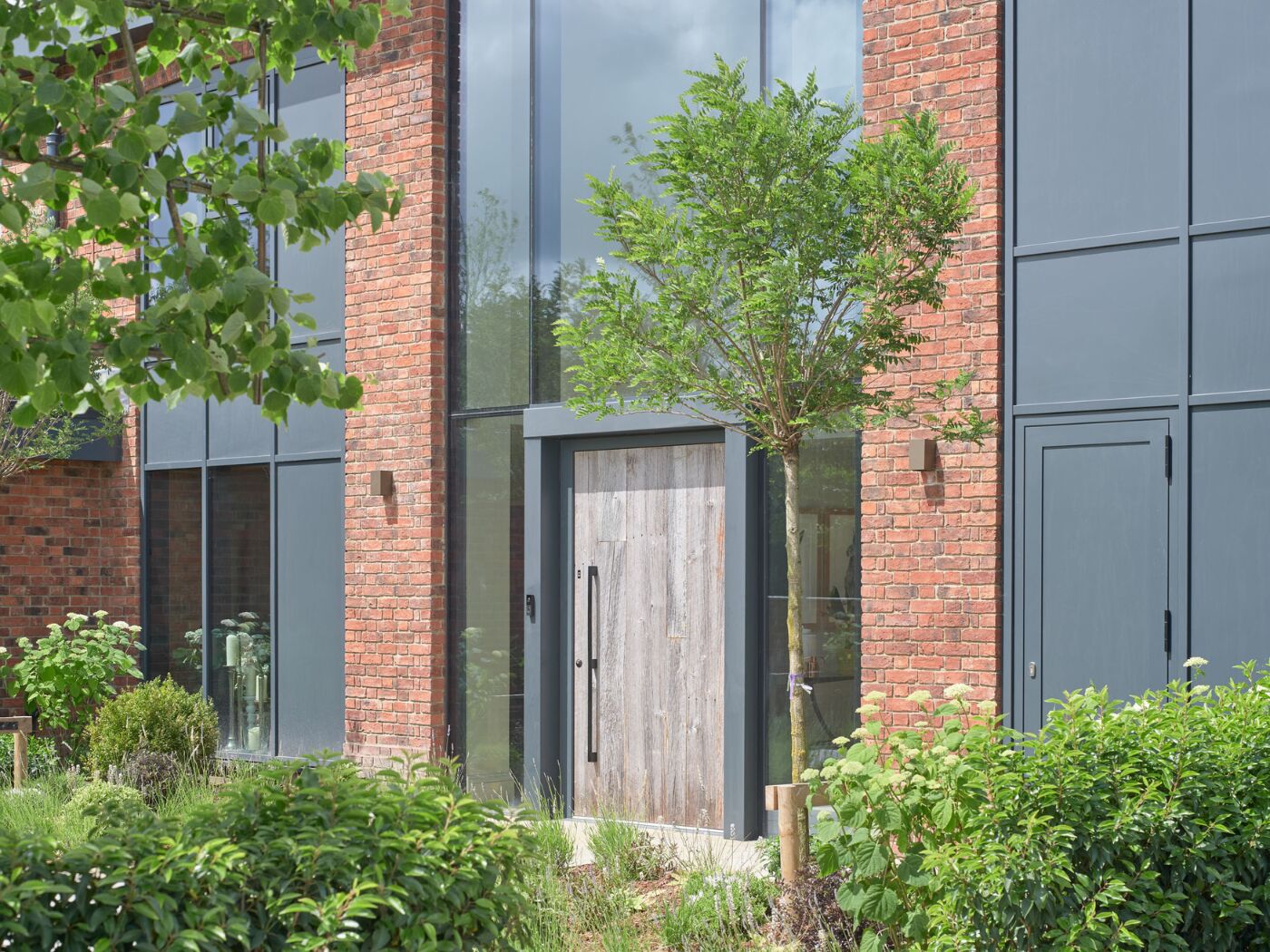 An oversized barn door chosen to feature within a wall of contemporary glazing.