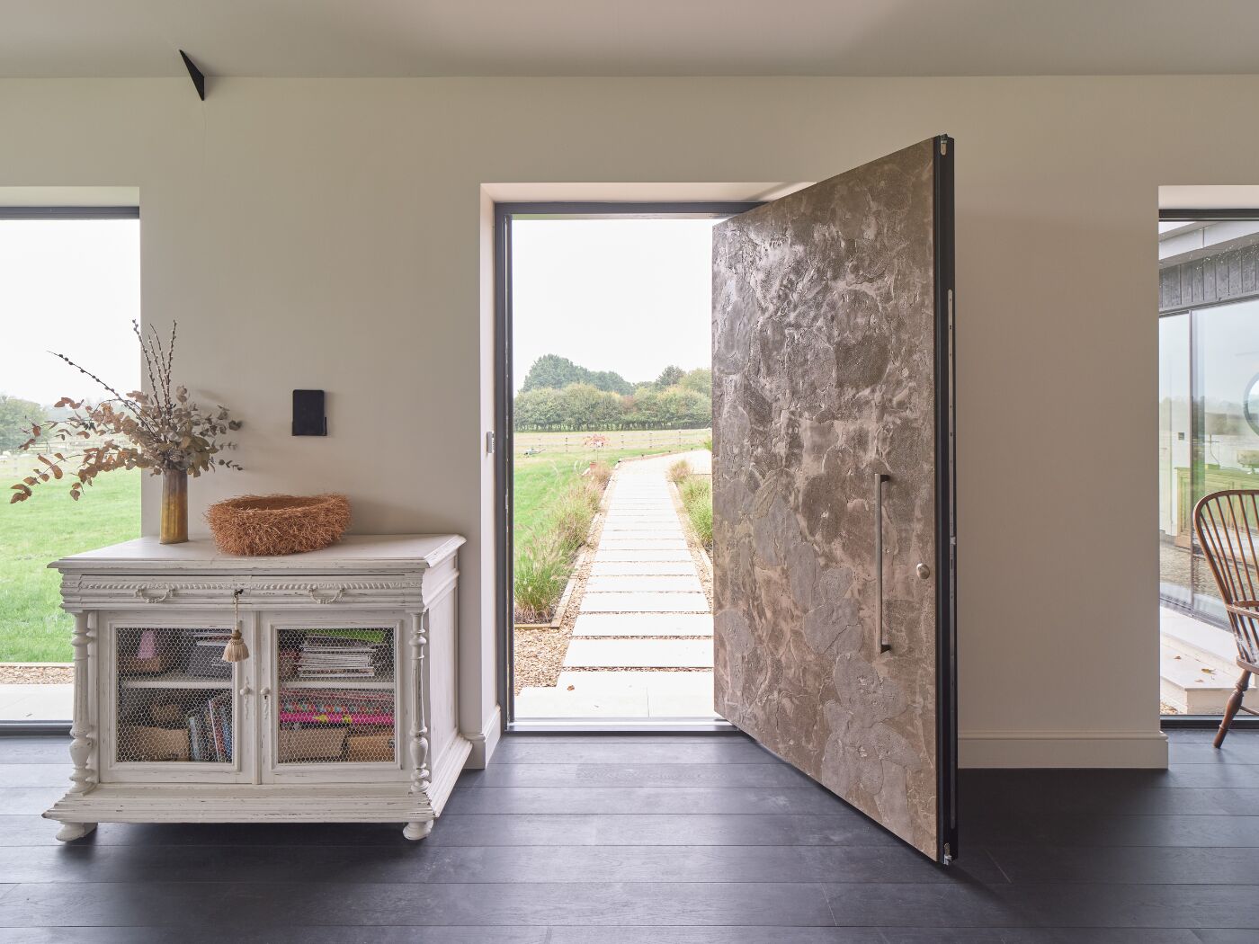 The bronze pivot door is a beautiful addition to this converted barn.