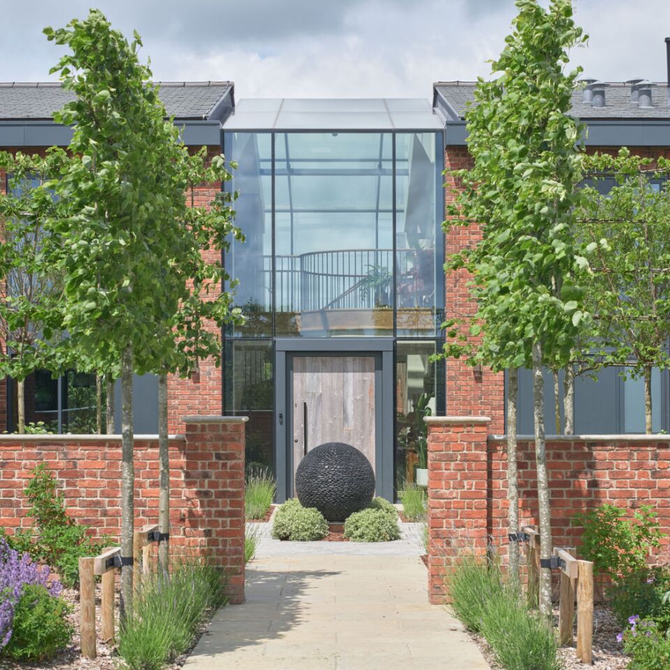 The reclaimed wood of the barn door creates impact within the architectural glazing.