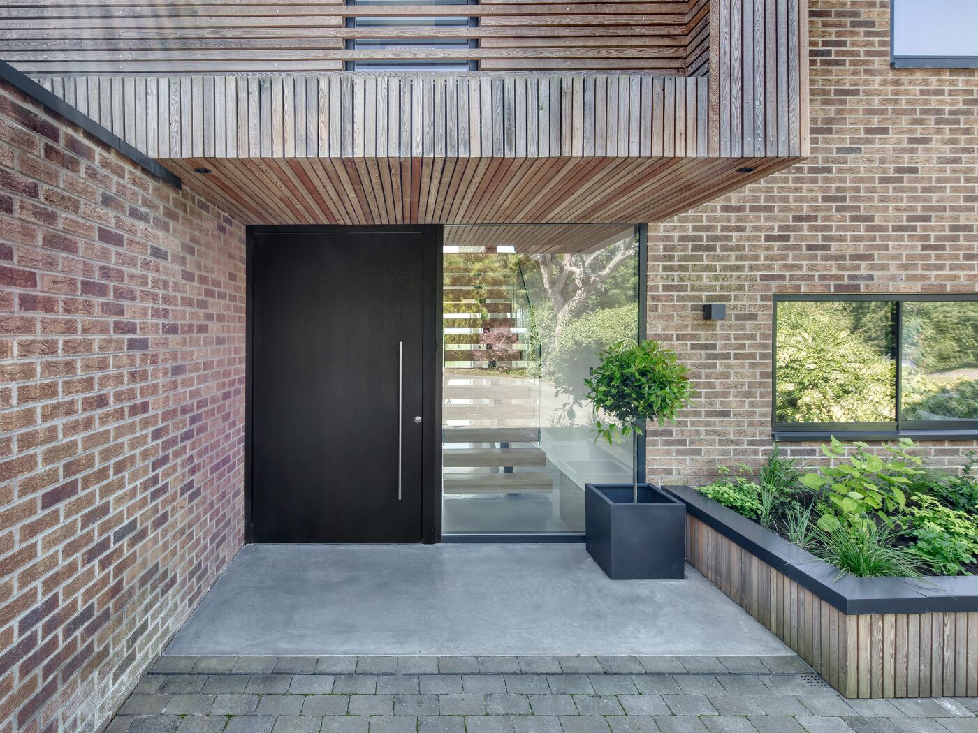 The oak door in ebony oil works beautifully with the brick, cladding and side glazing.