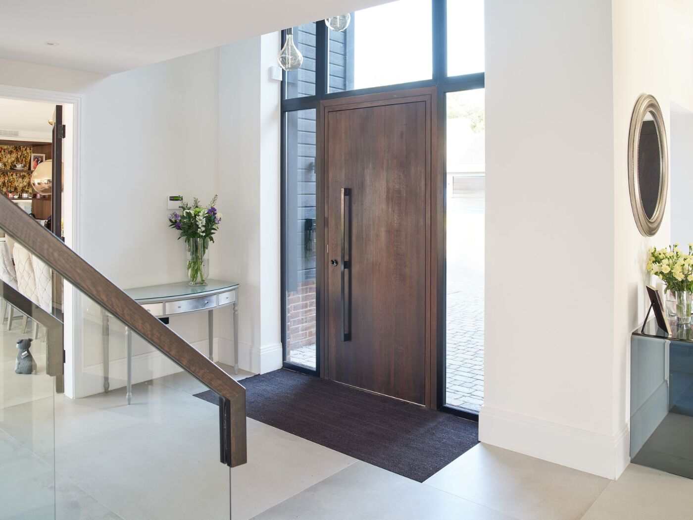 This dark door makes an impact in a hallway featuring white walls and glazing.