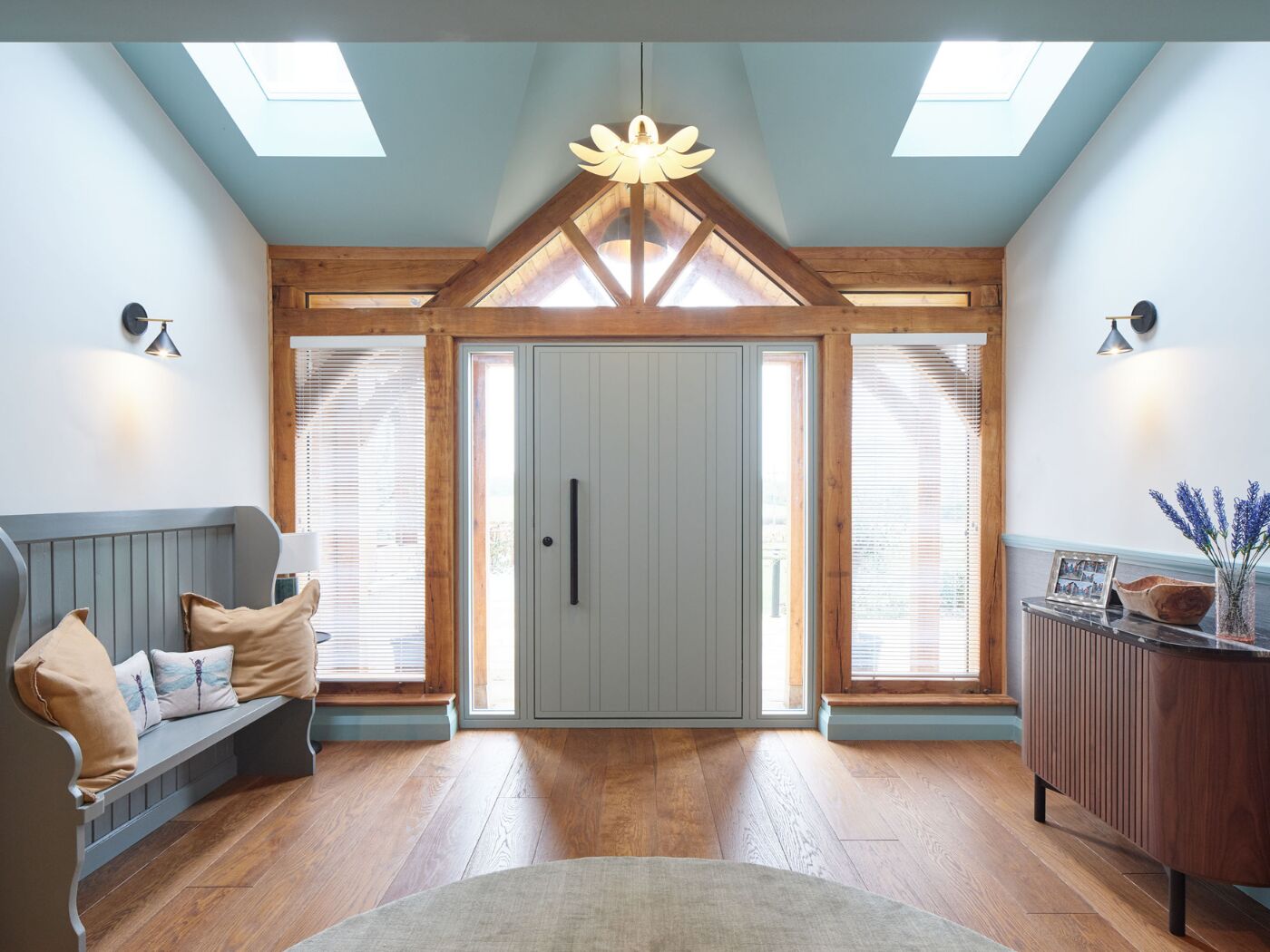 A spacious hallway filled with natural light featuring a RAL finish Rondo V door in Feldspar Silver.