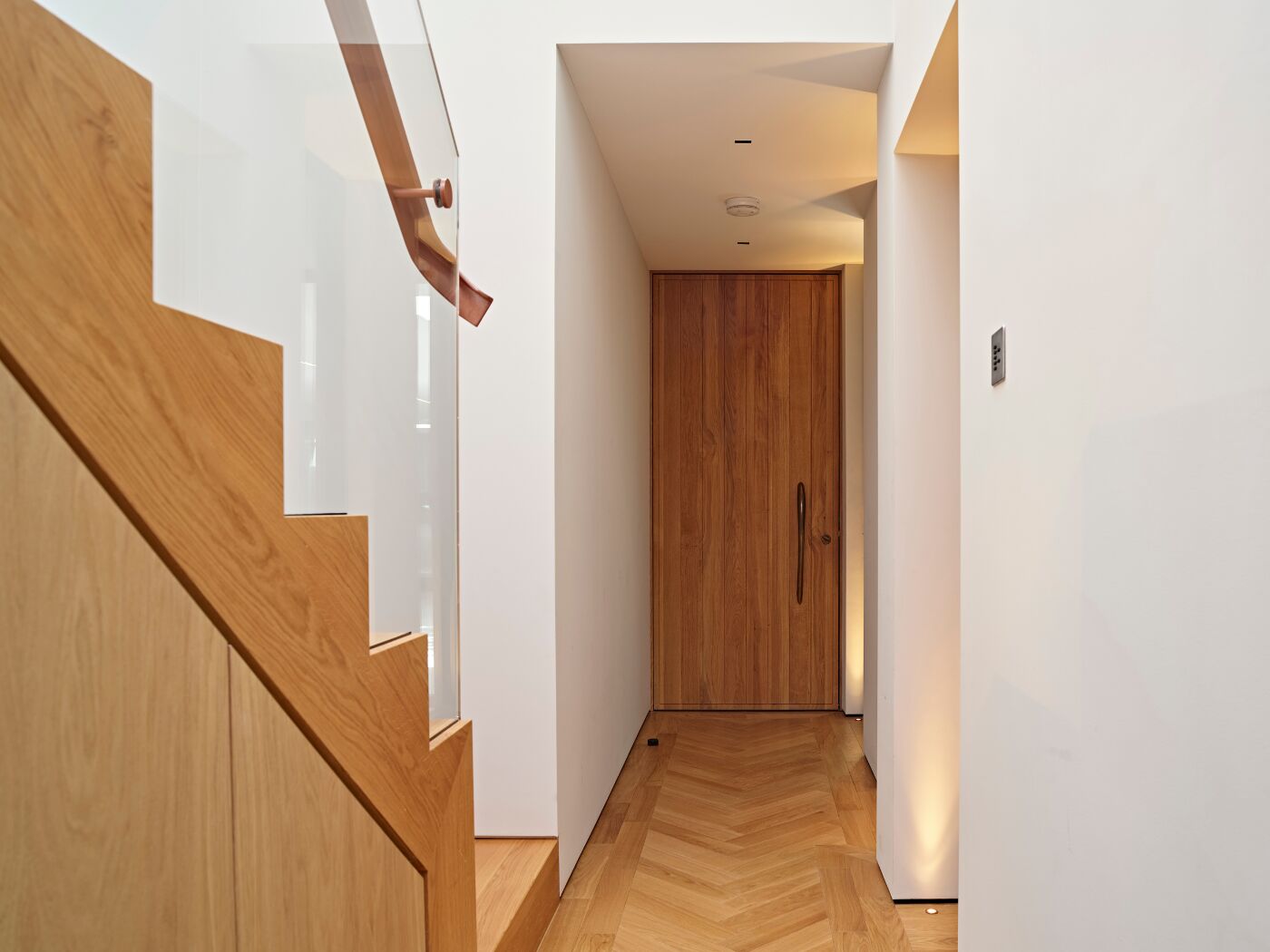 The wood of the staircase, floor and internal door complement each other in this hallway
