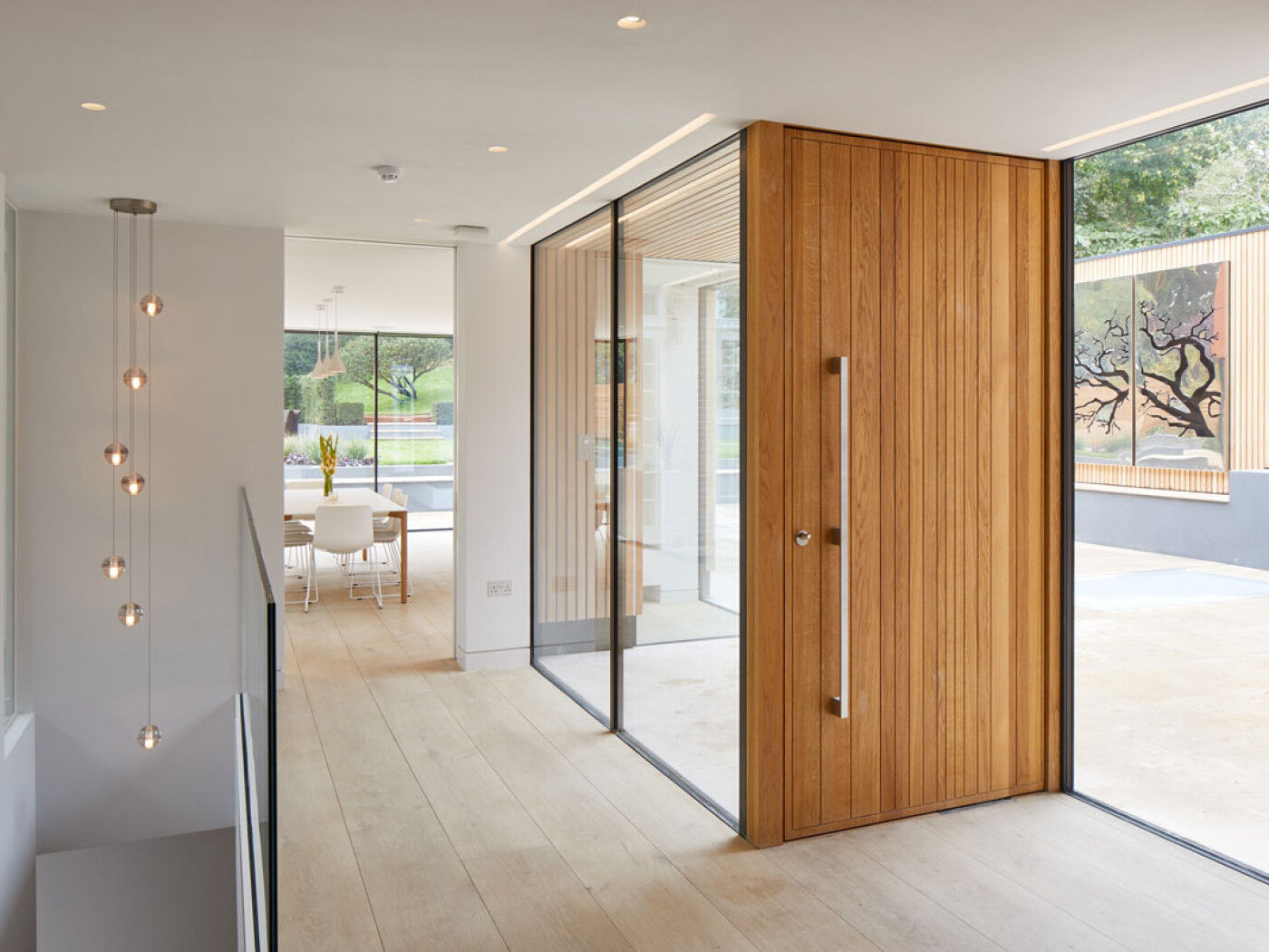 Neo oversized pivot front door | vertical grooves | European Oak | Option 11 handle