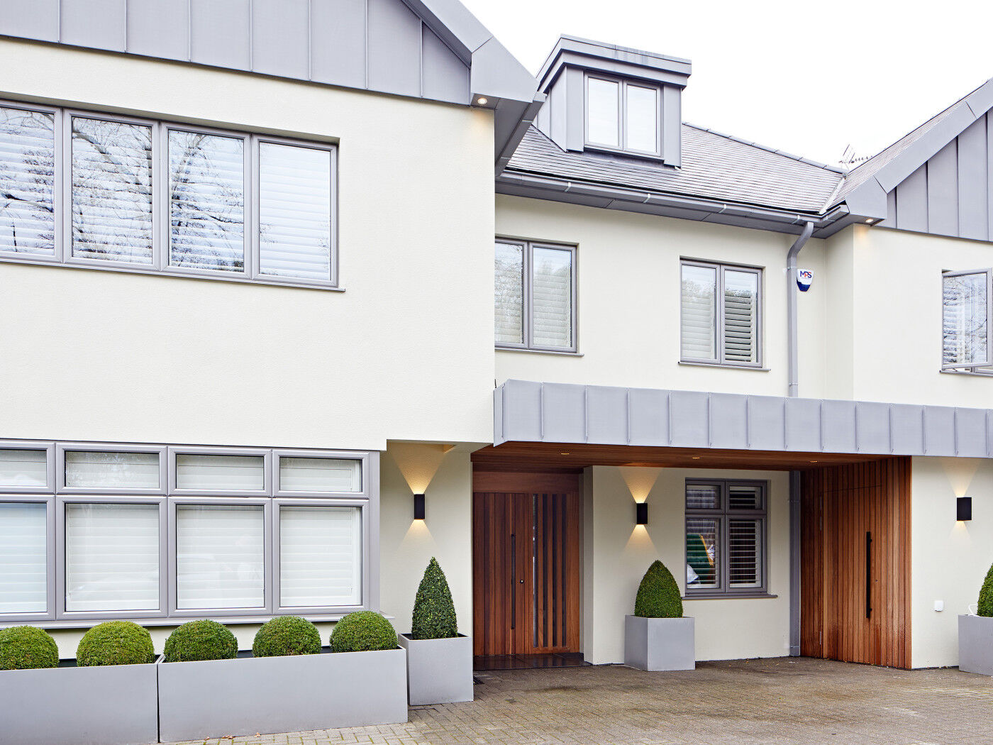 Outside, our "Ridge" in iroko works beautifully with the white rendered finish