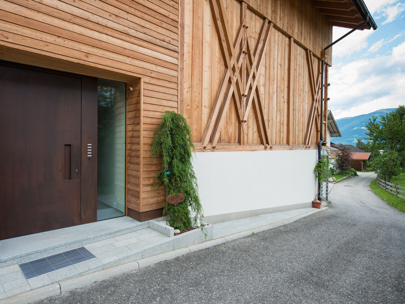 "Raw" steel front door in rust (corten steel), with concealed handle & glass sidelight