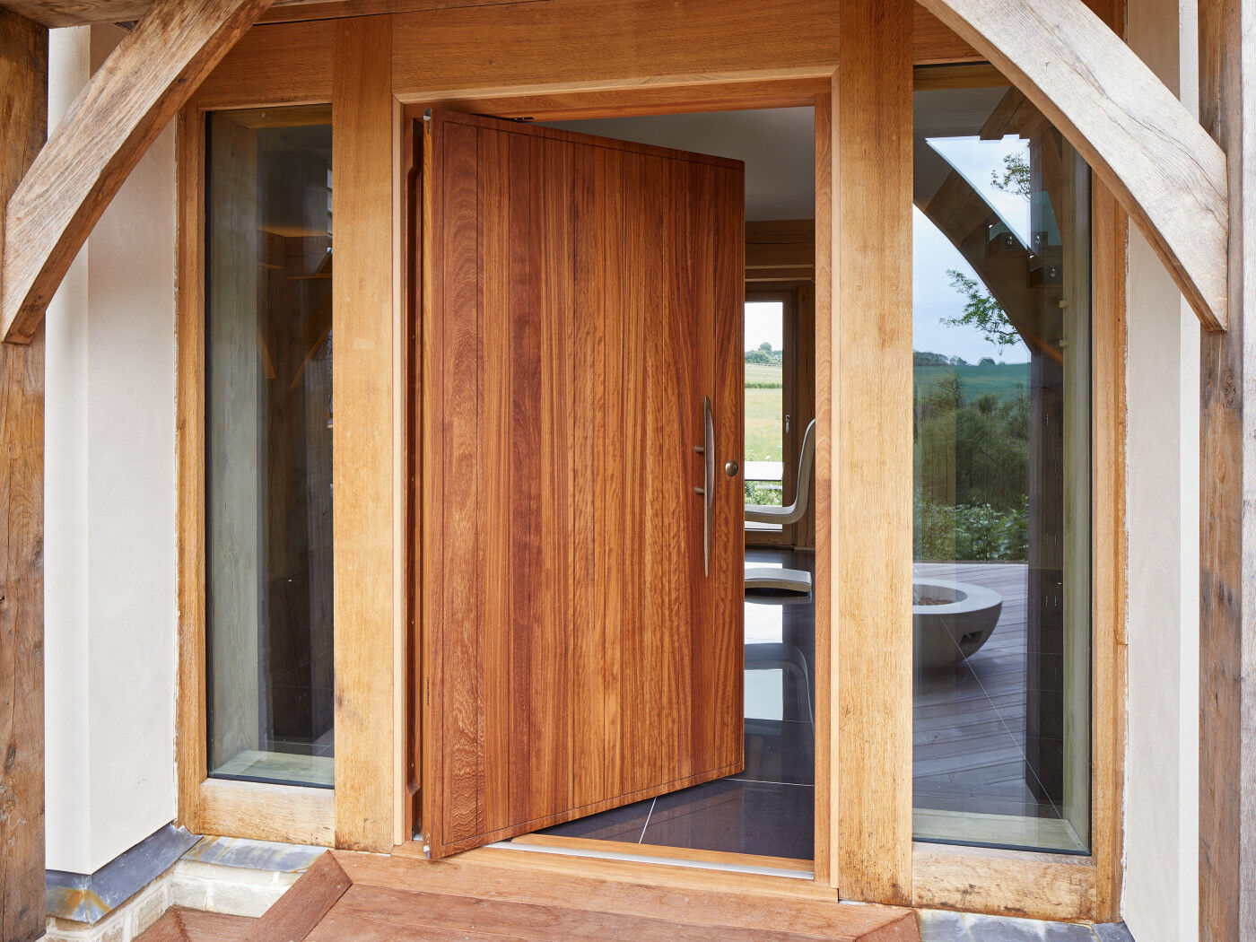 Rondo V door design in iroko + bronze handle and pivot opening